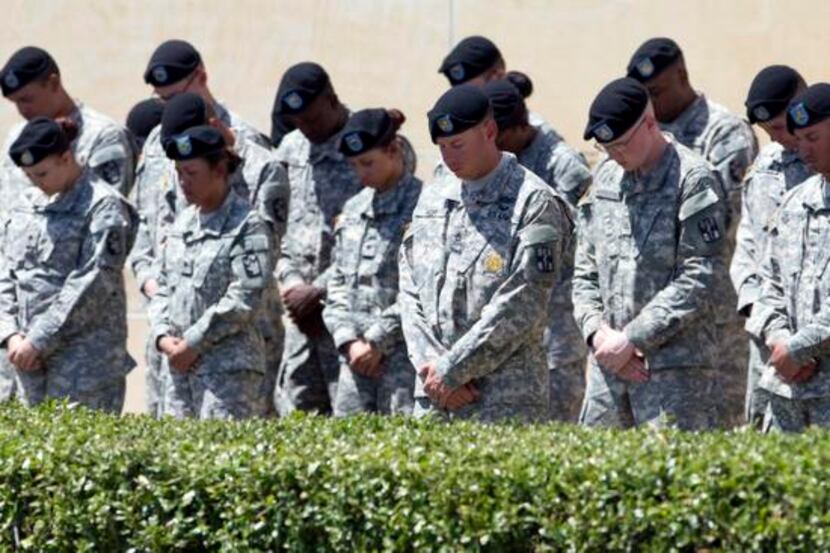 
Members of the military bow their heads during a memorial ceremony, Wednesday, April 9,...