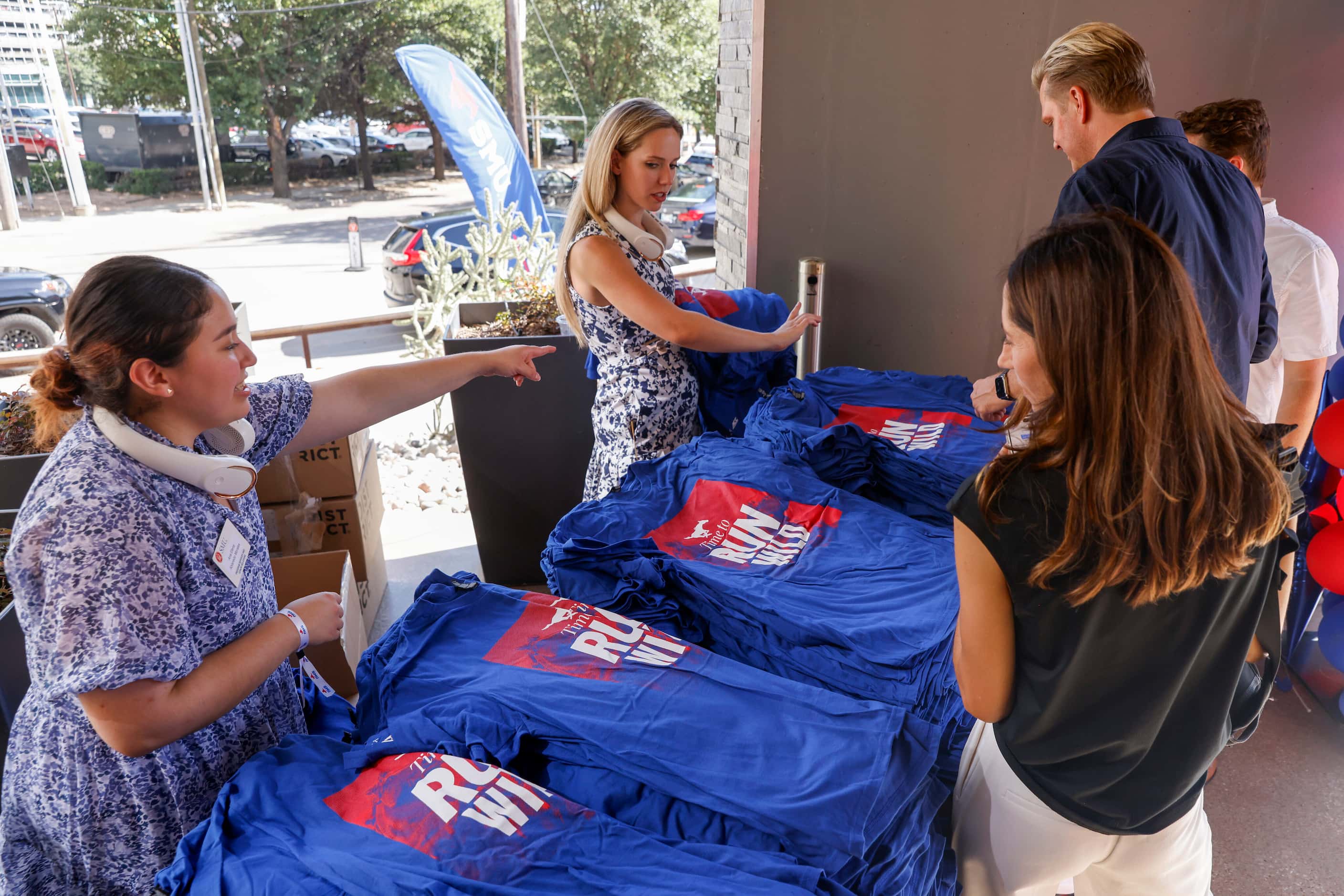People pick up SMU shirts during a celebration of SMU’s first day in the ACC at Happiest...