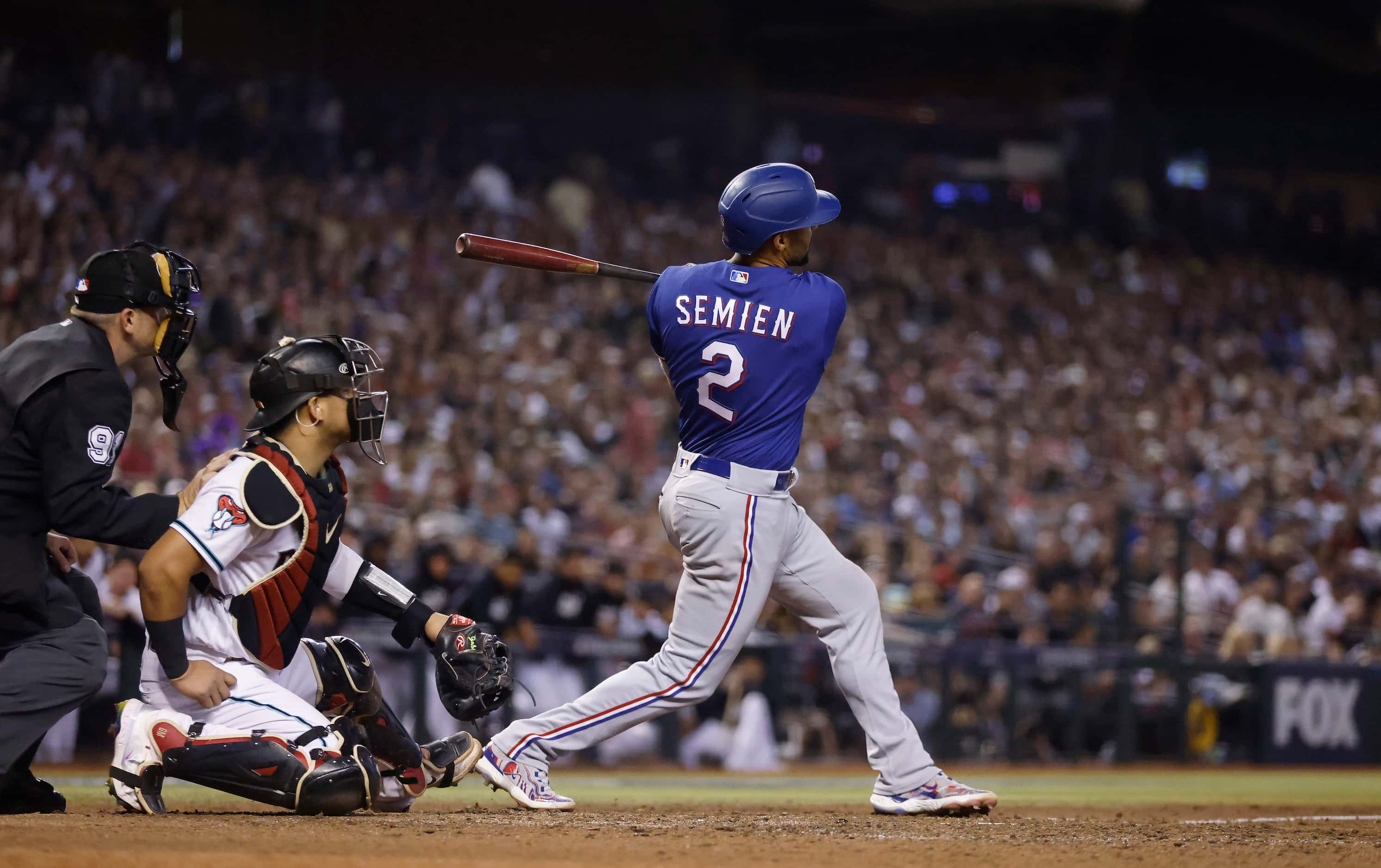 Texas Rangers second baseman Marcus Semien (2) follows through on a home run to left center...