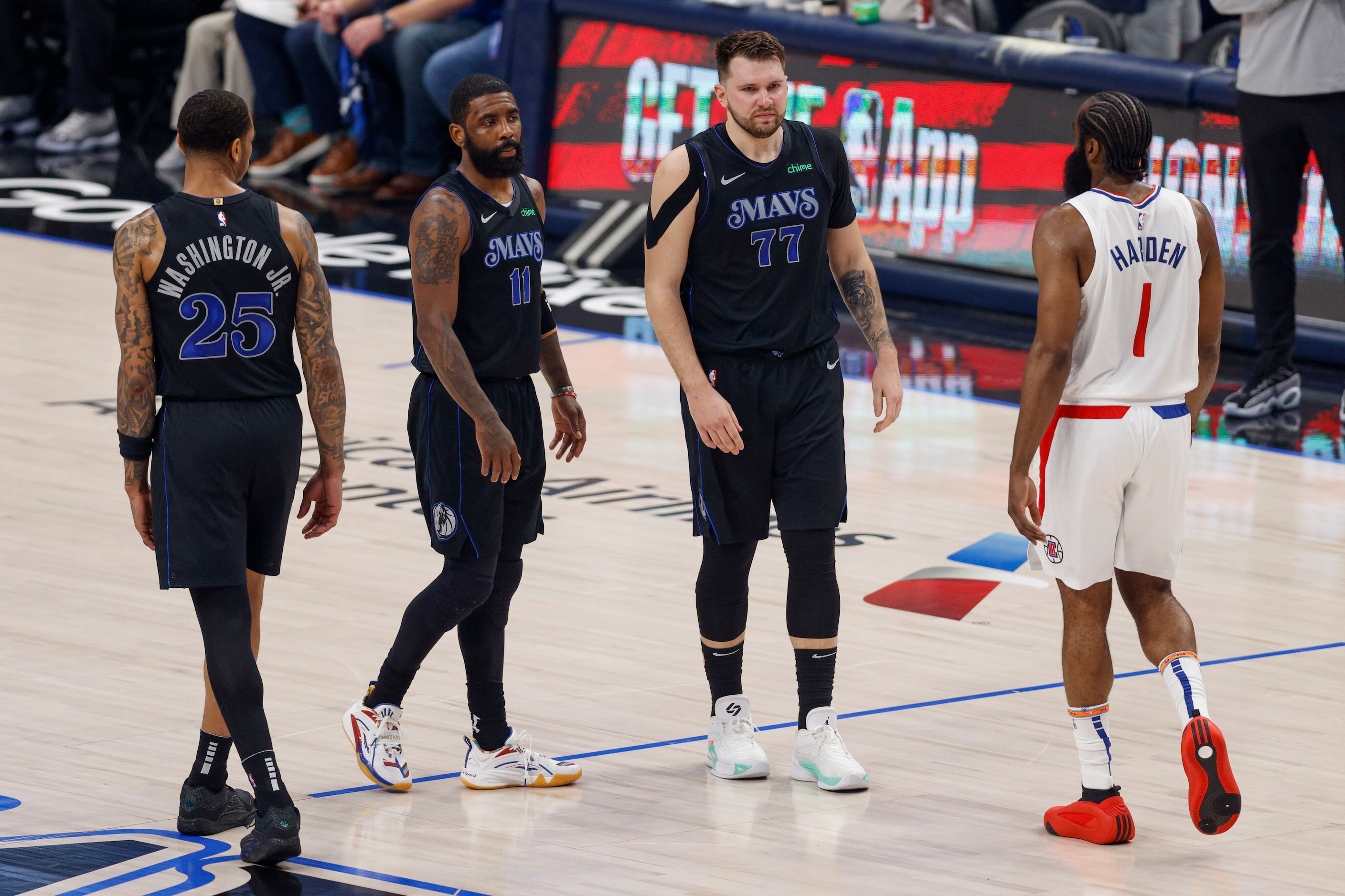 Dallas Mavericks guard Kyrie Irving (11) and guard Luka Doncic (77) walk past LA Clippers...