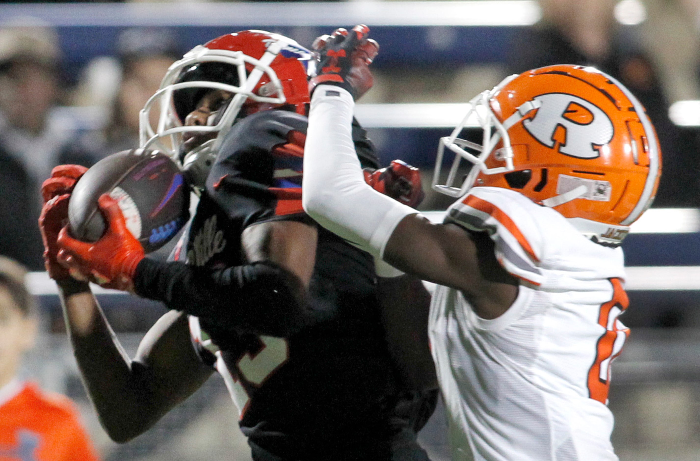 Duncanville receiver Emmanuel Ellison (13), left, pulls in a long pass as he is defended by...