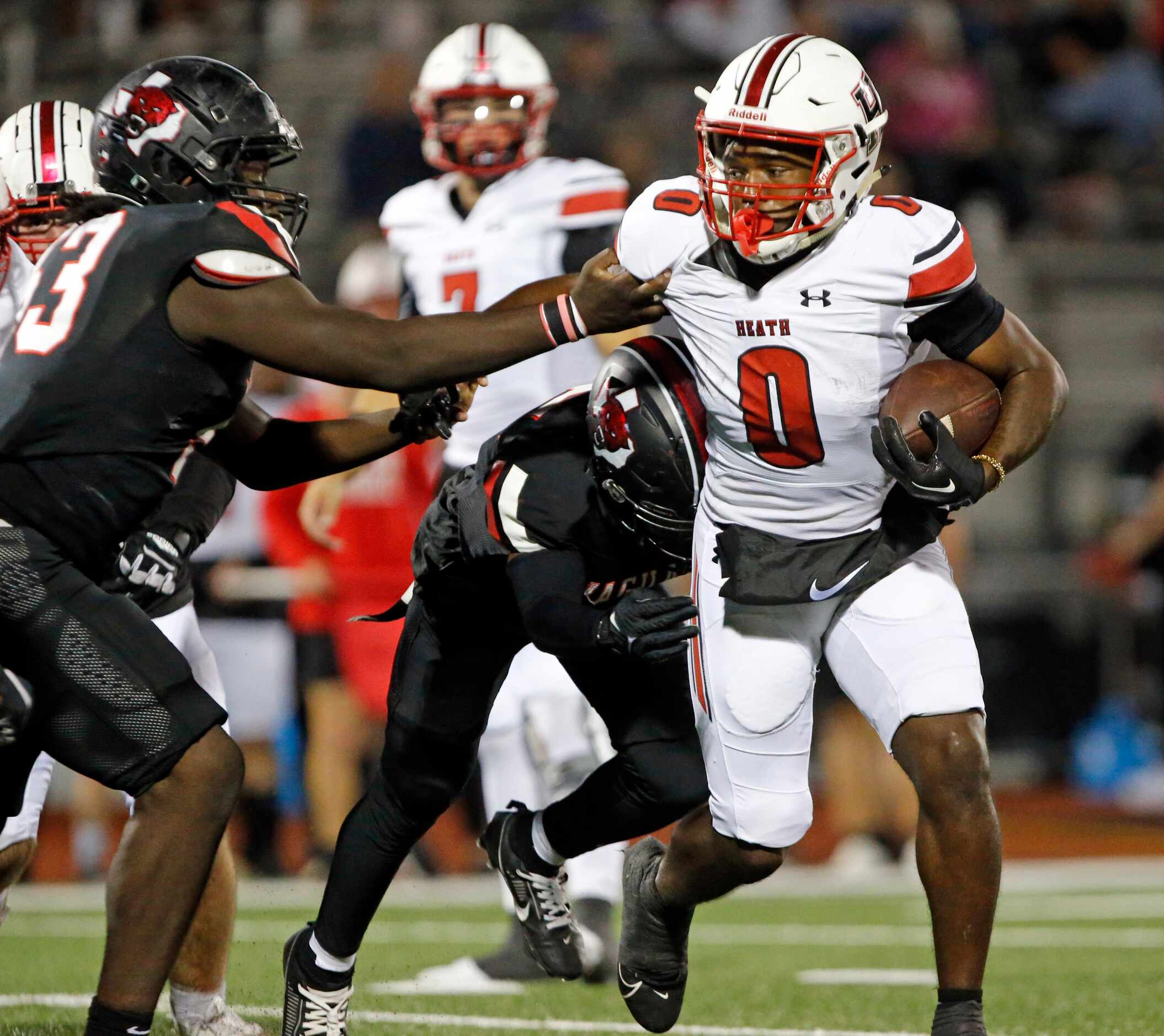 Rockwall Heath’s Malachi Tuesno (0) picks up a couple of yards during the first half of a...