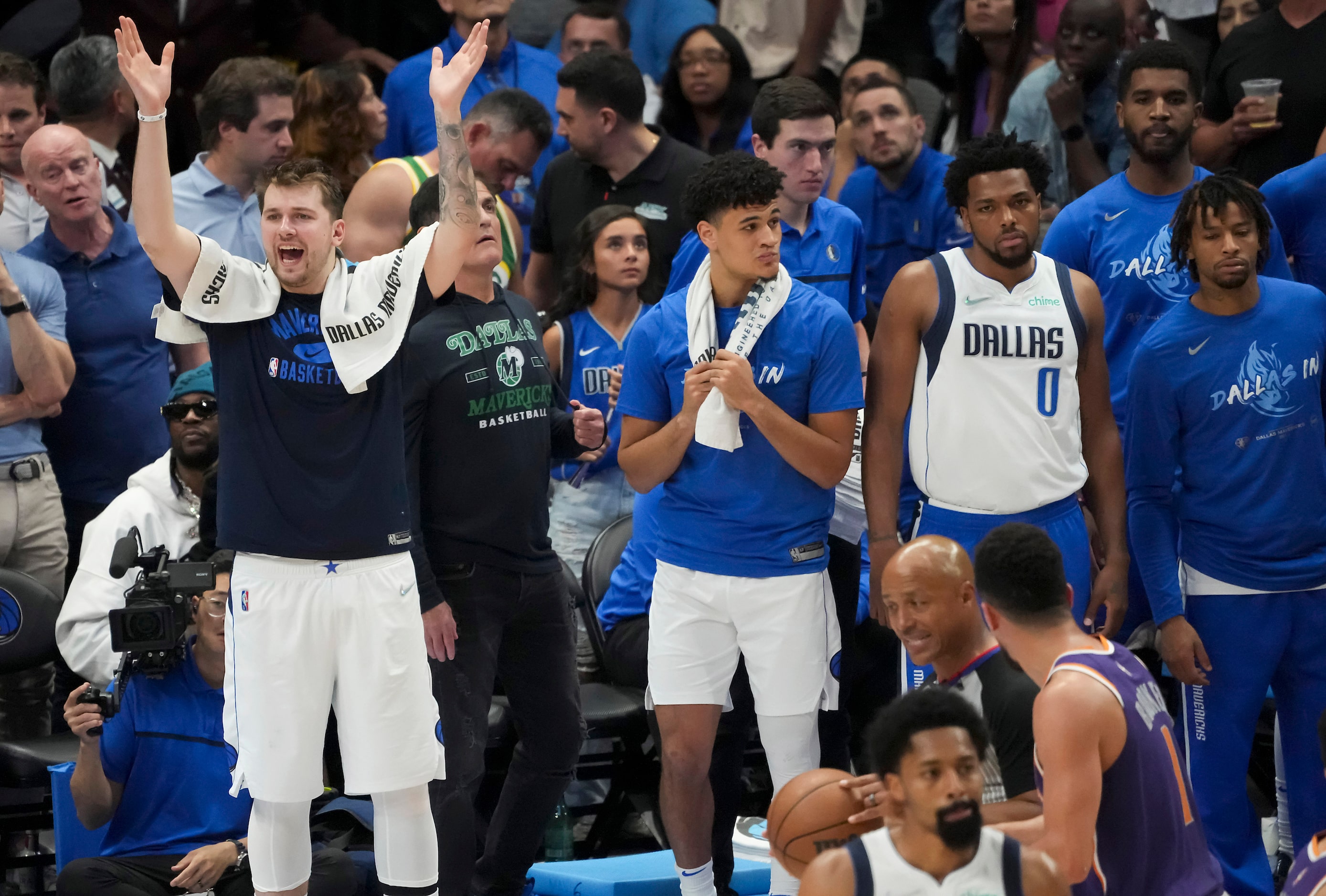 Dallas Mavericks guard Luka Doncic (77) cheers his teammates from the bench after picking up...