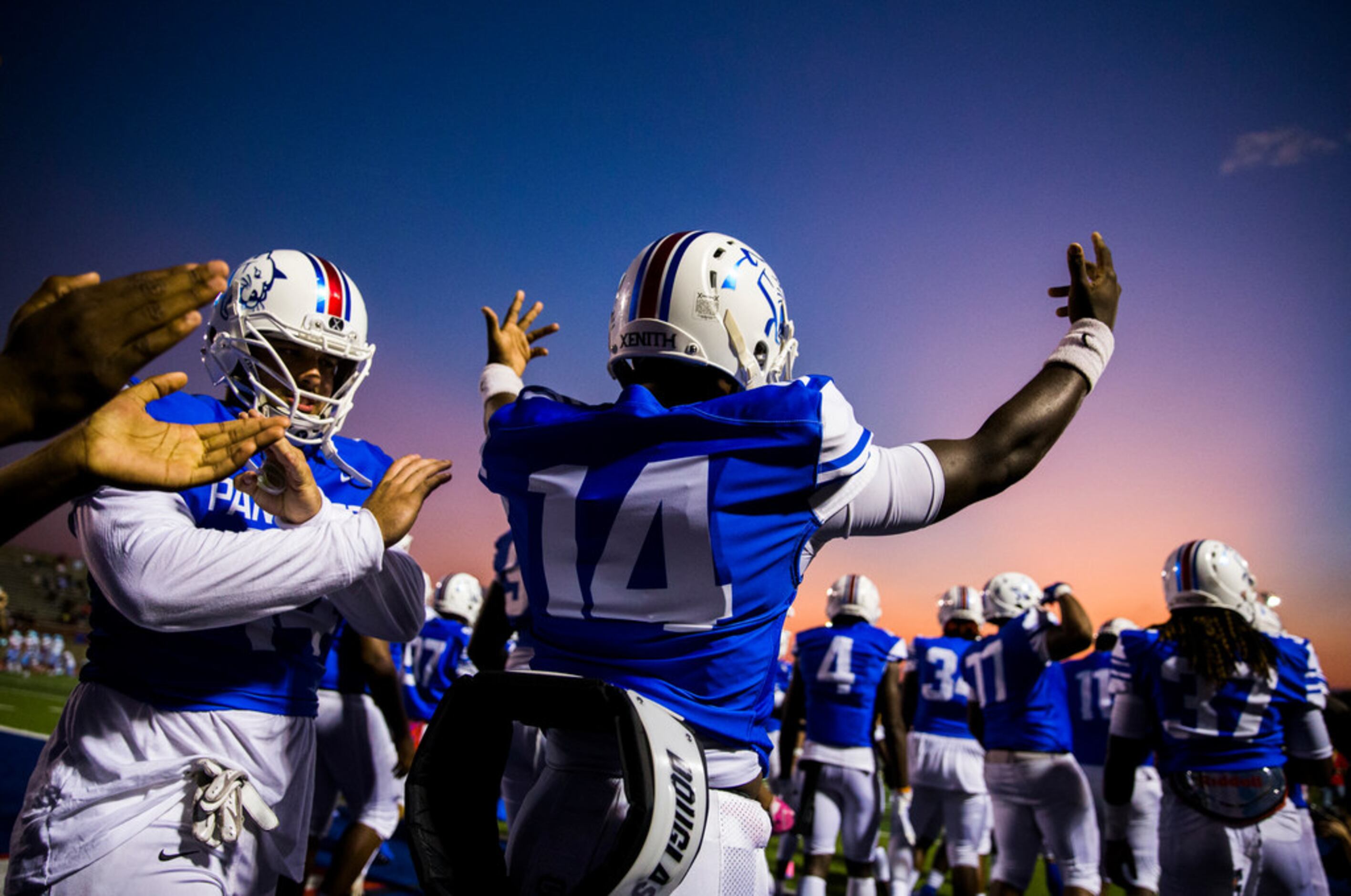 Duncanville quarterback Chris Parson (14) hypes up the crowd as he enters the field before a...