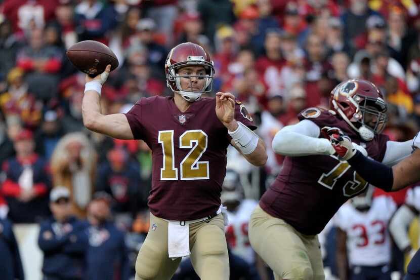 Washington Redskins quarterback Colt McCoy (left) throws the ball during an NFL football...