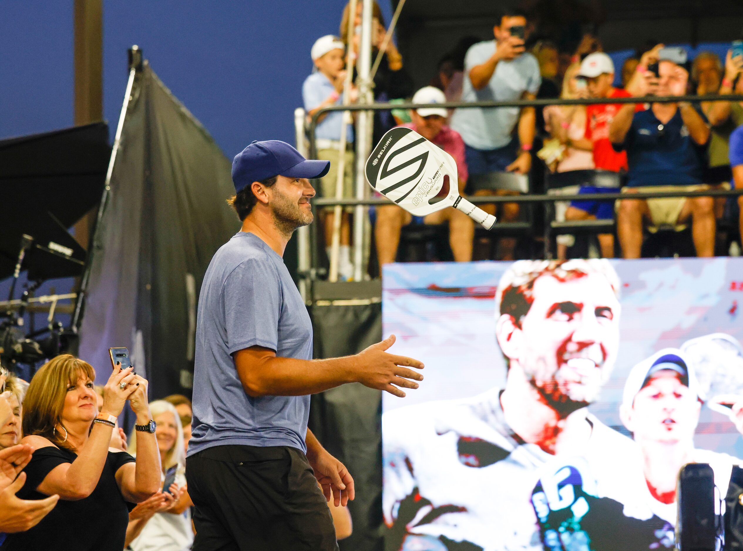 Tony Romo flips a pickleball paddle as he enters the court for the Dick’s Sporting Goods...