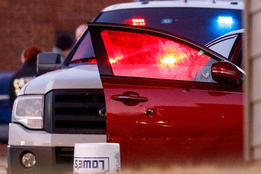 Bullet holes are seen in the passenger side door of a four door sedan after a Dallas police...