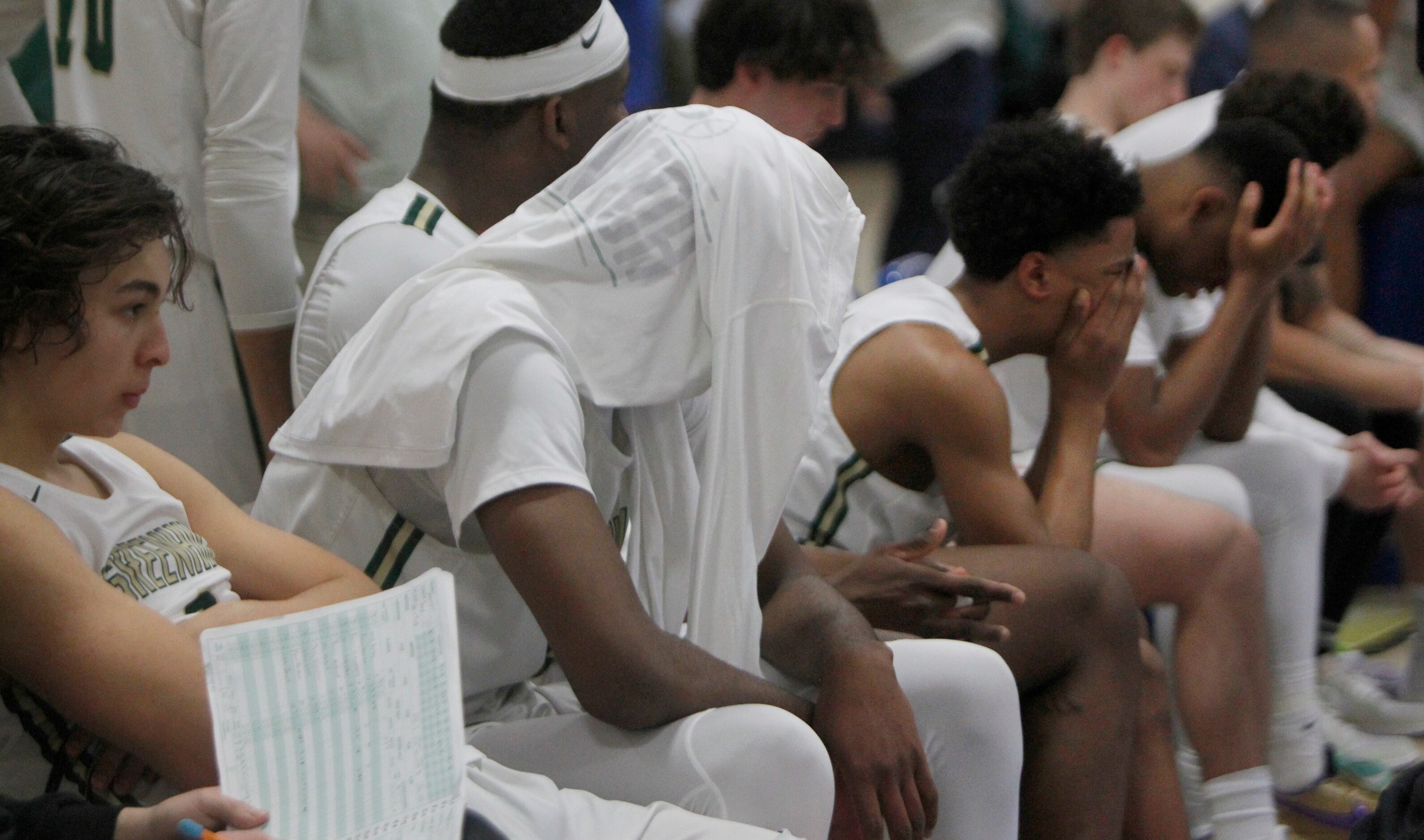 Greenhill players sit in disbelief on the team bench after their 56-55 buzzer-beater loss to...