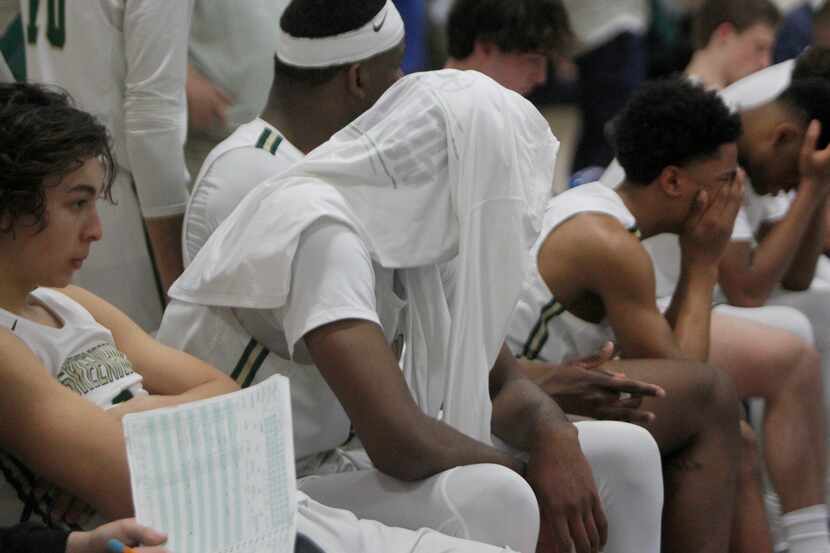 Greenhill players sit in disbelief on the team bench after their 56-55 buzzer-beater loss to...