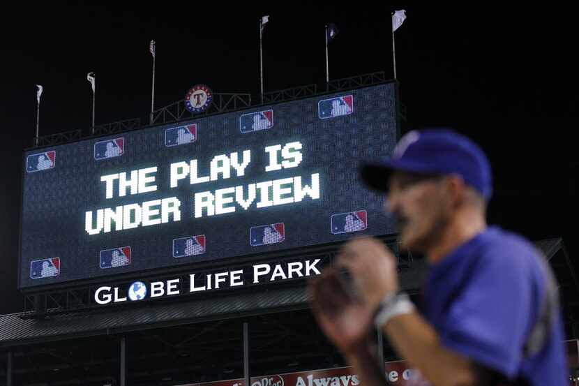 The Play is Under Review sign is displayed on the video board during the Texas Rangers...