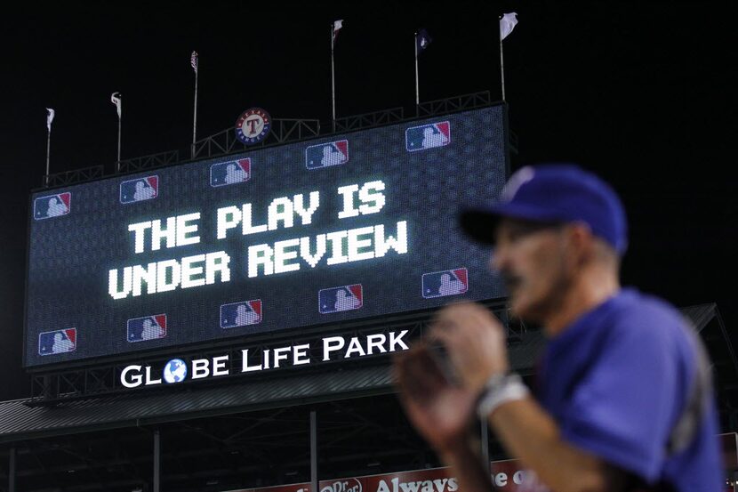 The Play is Under Review sign is displayed on the video board during the Texas Rangers...