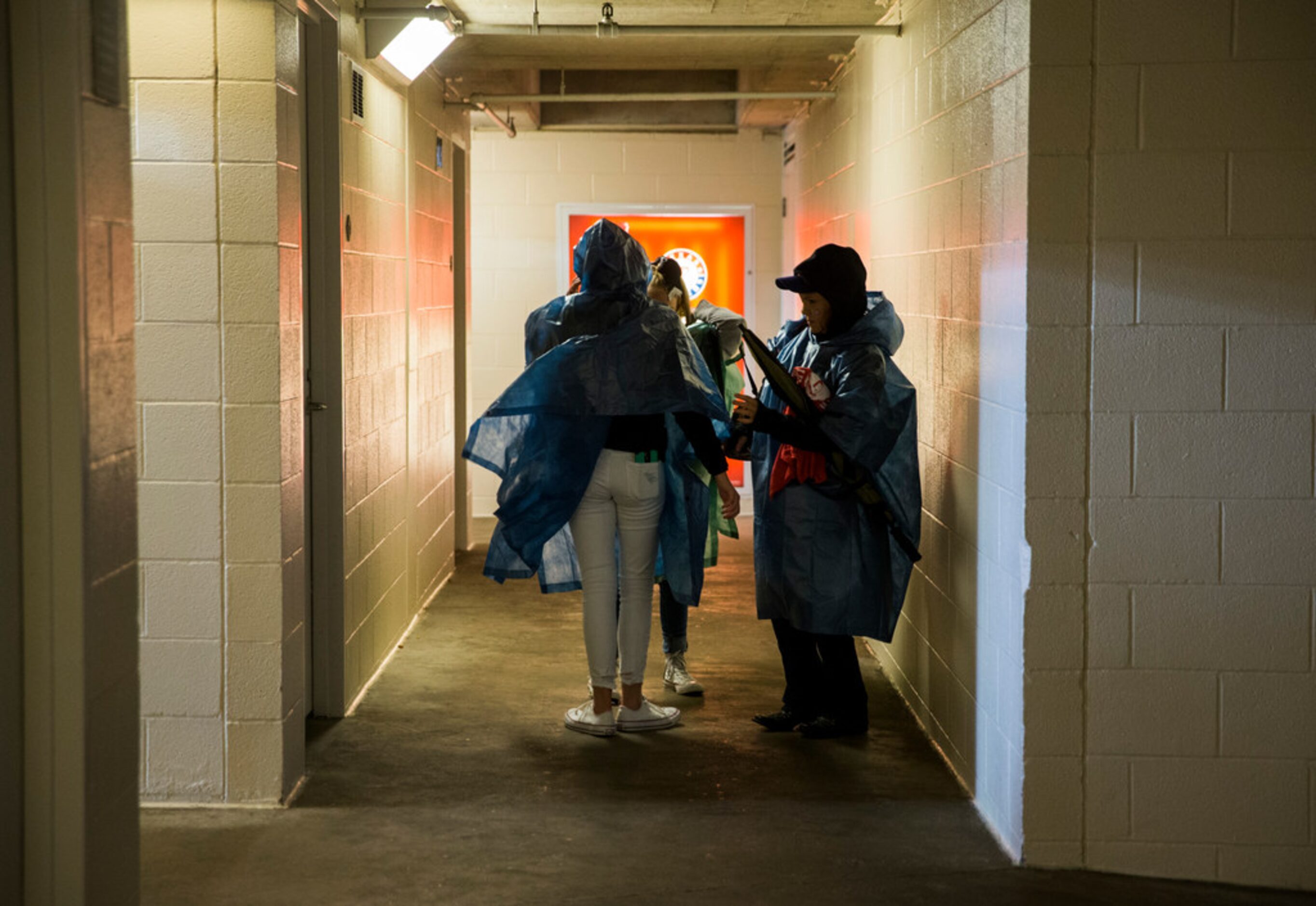 Texas Rangers fans put on ponchos during a rain delay at an MLB game between the Texas...