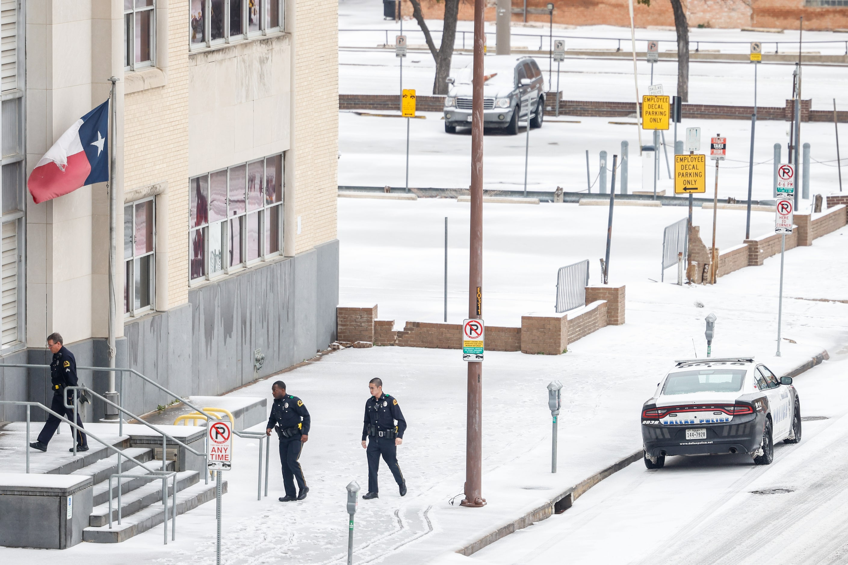 Dallas Police officers enter the CIty of Dallas Municipal Court as sleet covered Commerce St...