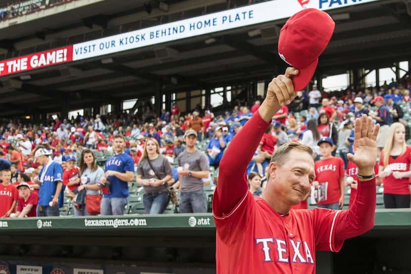 Texas Rangers manager Jeff Banister tips his cap to the crowd before a game against the...