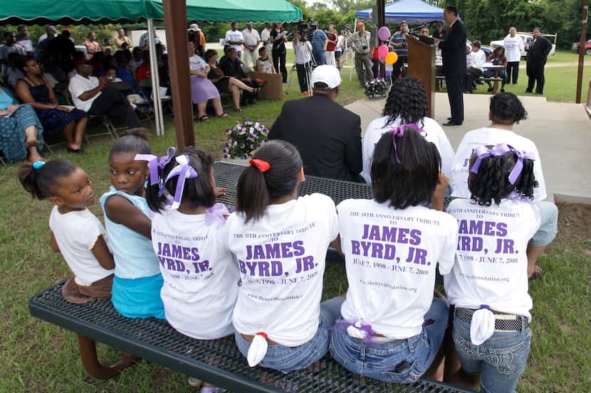 Children sit at a picnic table during a 10th anniversary tribute to James Byrd Jr. in...