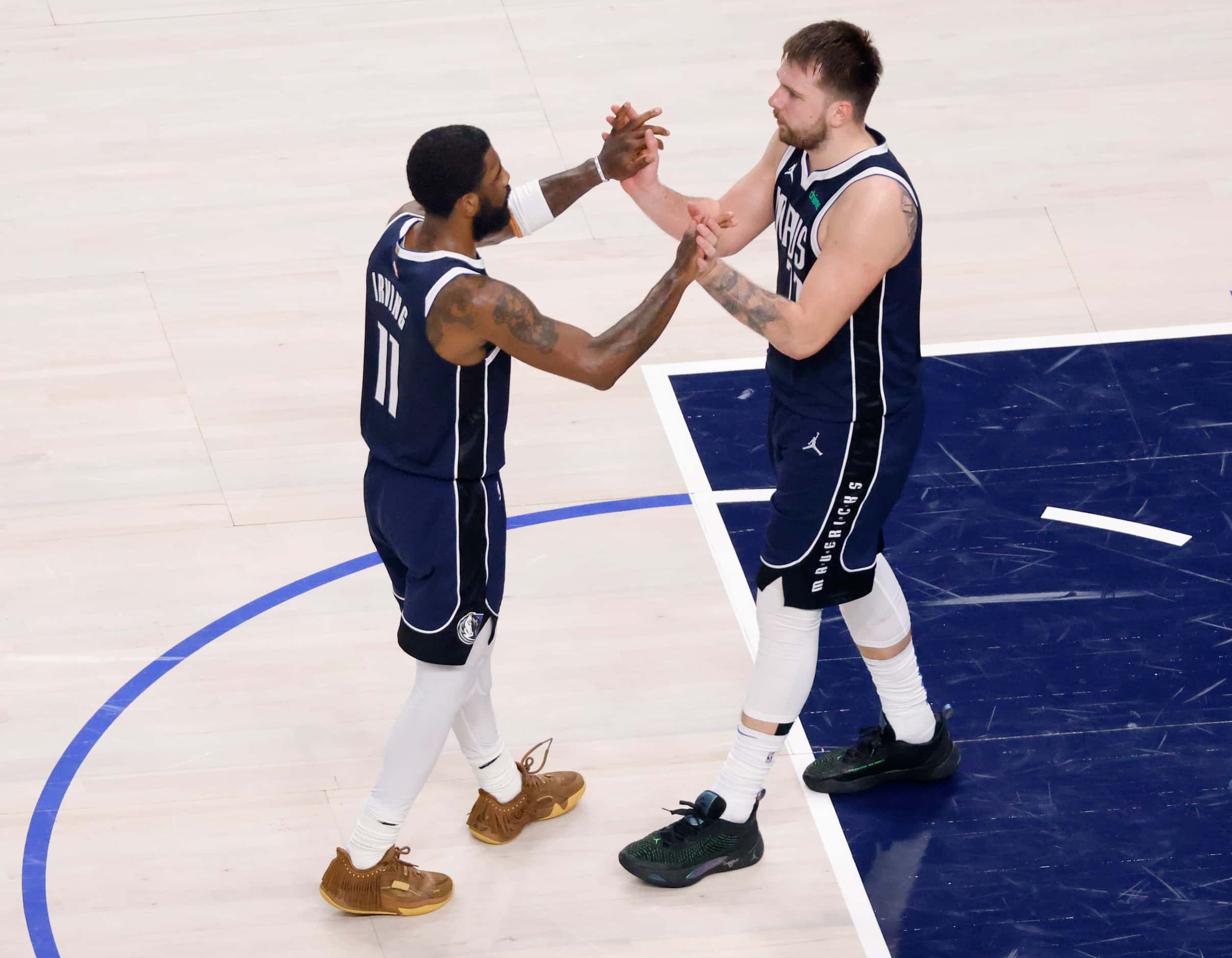Dallas Mavericks guards Kyrie Irving (11) and Luka Doncic (77) high five one another late in...