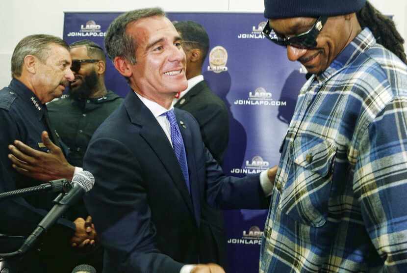 Rapper Snoop Dogg, right, and Los Angeles Mayor Eric Garcetti talk after a news conference...