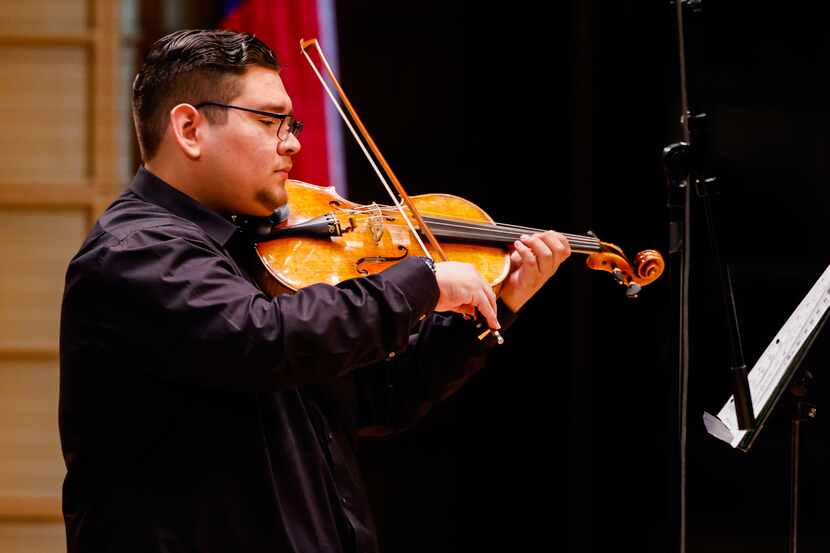 El estudiante de preparatoria Ángel de Hoyos toca el violín en el escenario del Morton H....