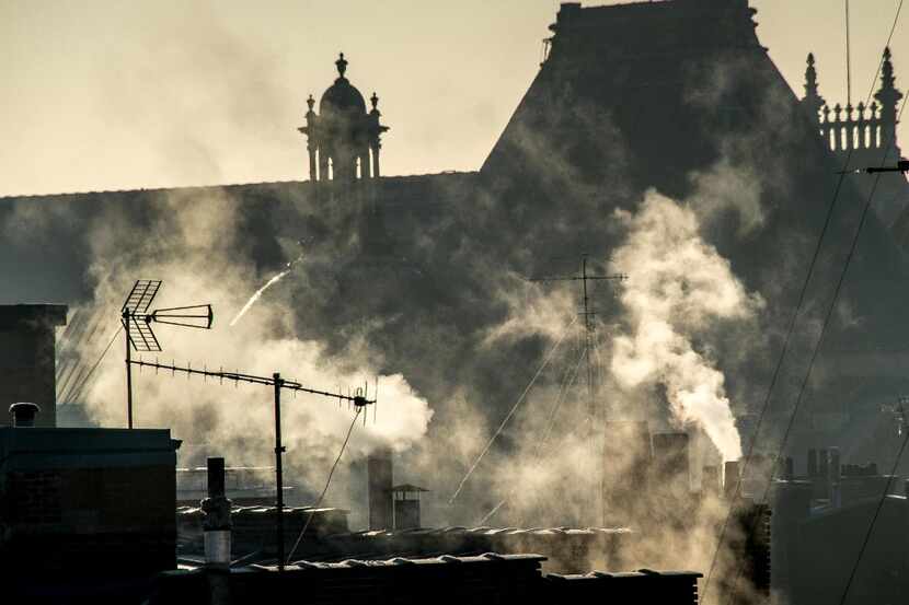 Chimneys emit smoke on a freezing day in the city of Lille in northern France on December...