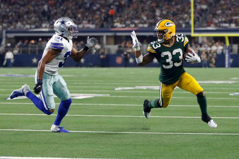 Green Bay Packers running back Aaron Jones (33) waves towards Dallas Cowboys cornerback...