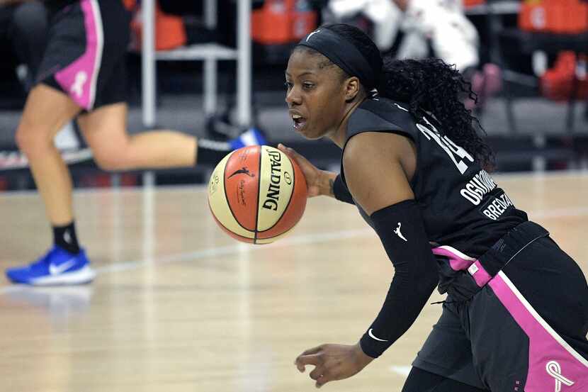 Dallas Wings guard Arike Ogunbowale (24) pushes the ball up the court during the first half...
