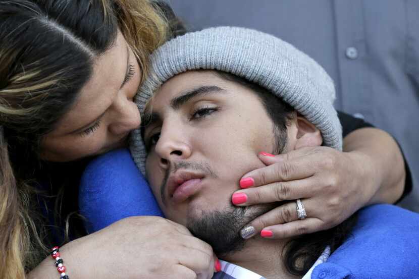  Confined to a wheelchair, Sergio Molina, right, is hugged by his mother Maria Lemus after a...