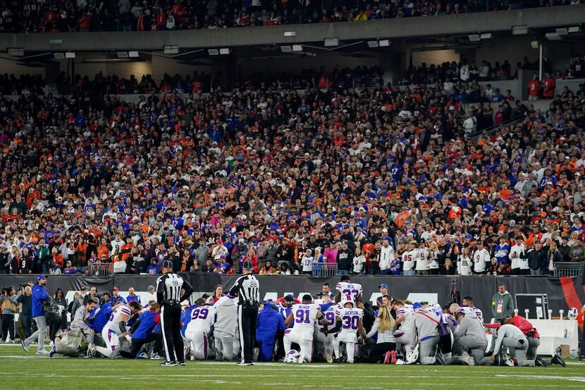 Buffalo Bills players kneel after teammate Damar Hamlin is injured during the first half of...