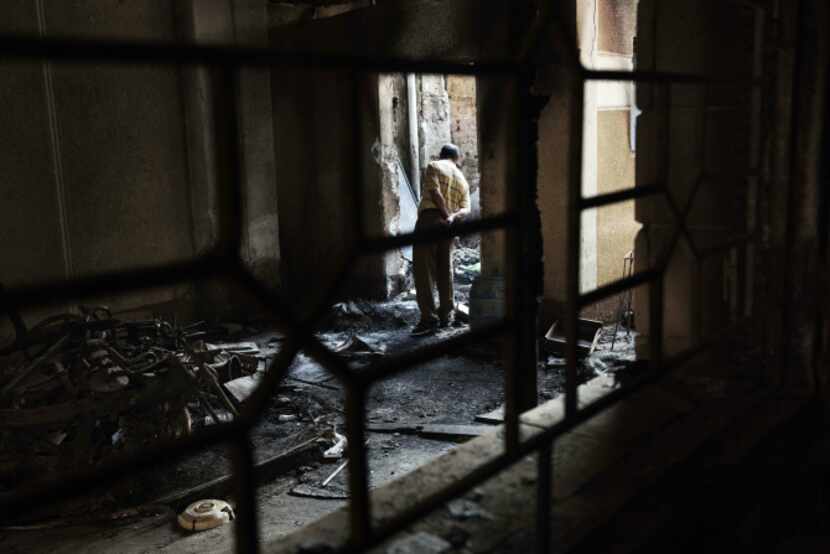 An Egyptian inspects debris in a room of the Jesuit College compound in Minya that was...