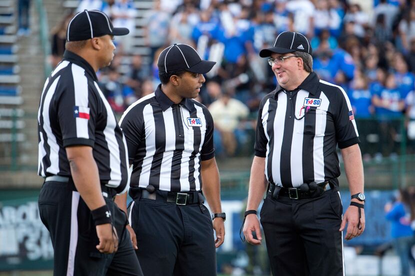 Referees confer before a high school football game between Grand Prairie and South Grand...