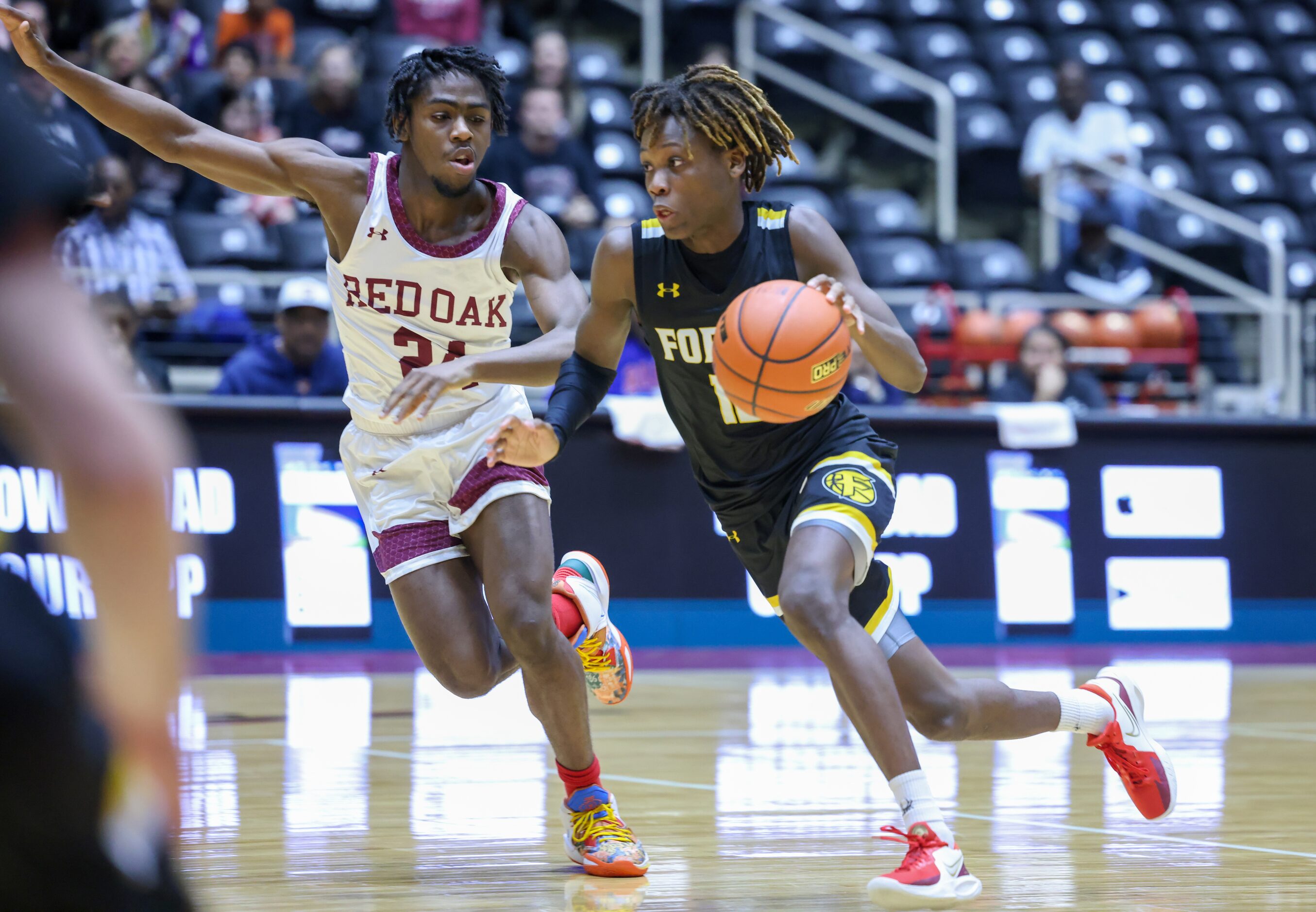 Red Oak junior guard Kamal Brooks (24, left) raises an arm while following Forney senior...