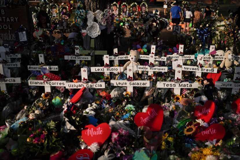 Flowers were piled around crosses with the names of the victims killed in a school shooting...