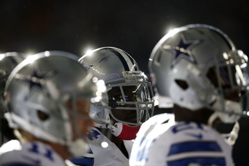 Members of the Dallas Cowboys stand on the sideline watching late in the second half of an...