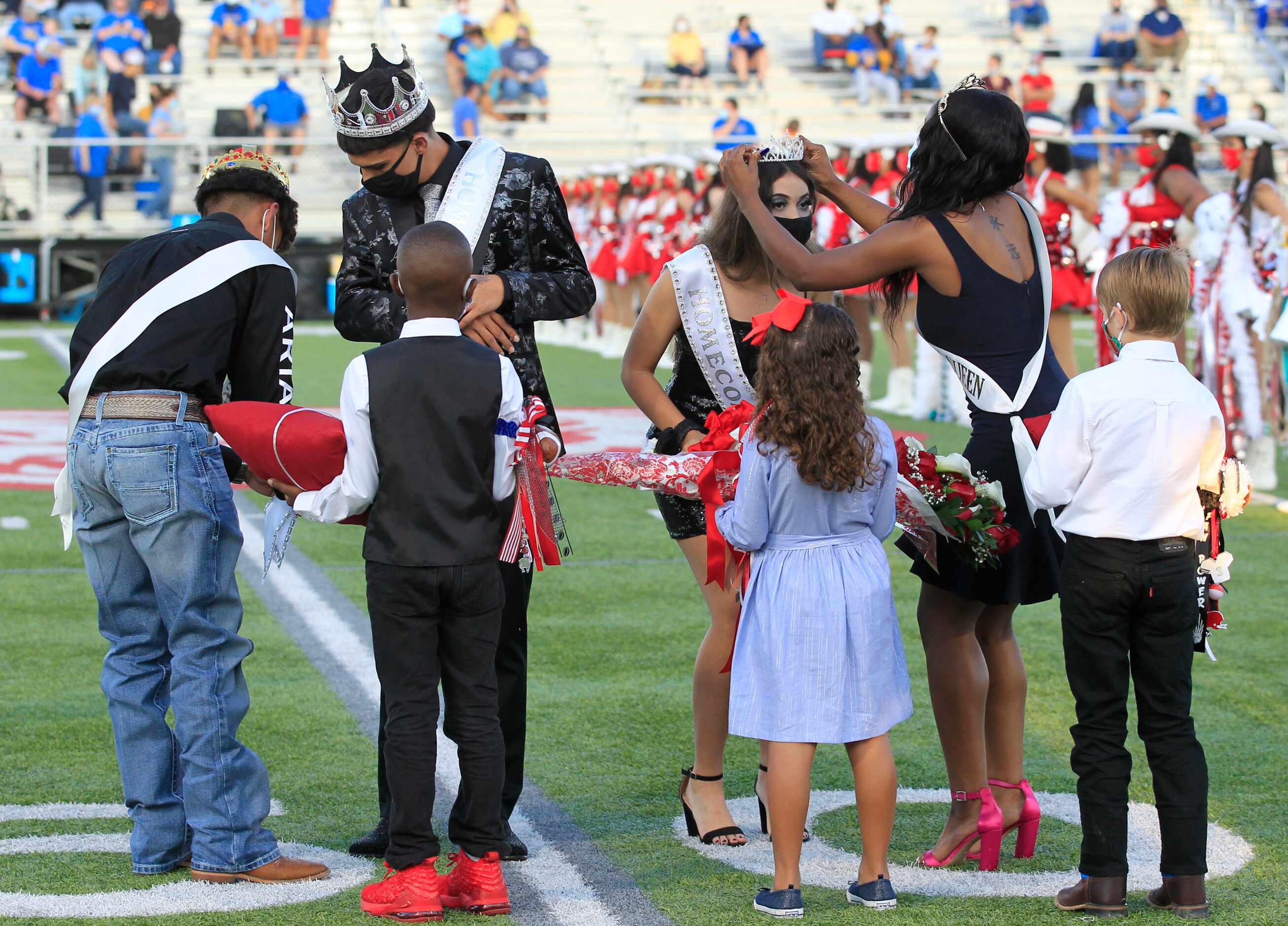 Terrell Homecoming King Gavin Patrick and queen Kylie Peterson (both in masks) are crowned...