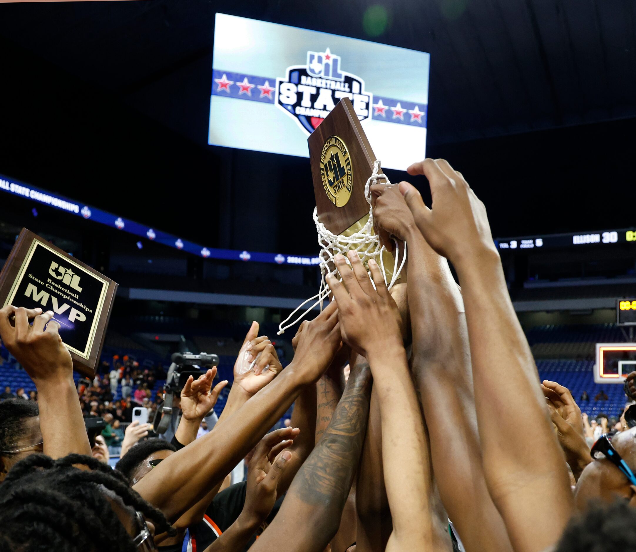 Lancaster team members reach to touch their trophy after winning the UIL Class 5A boys...