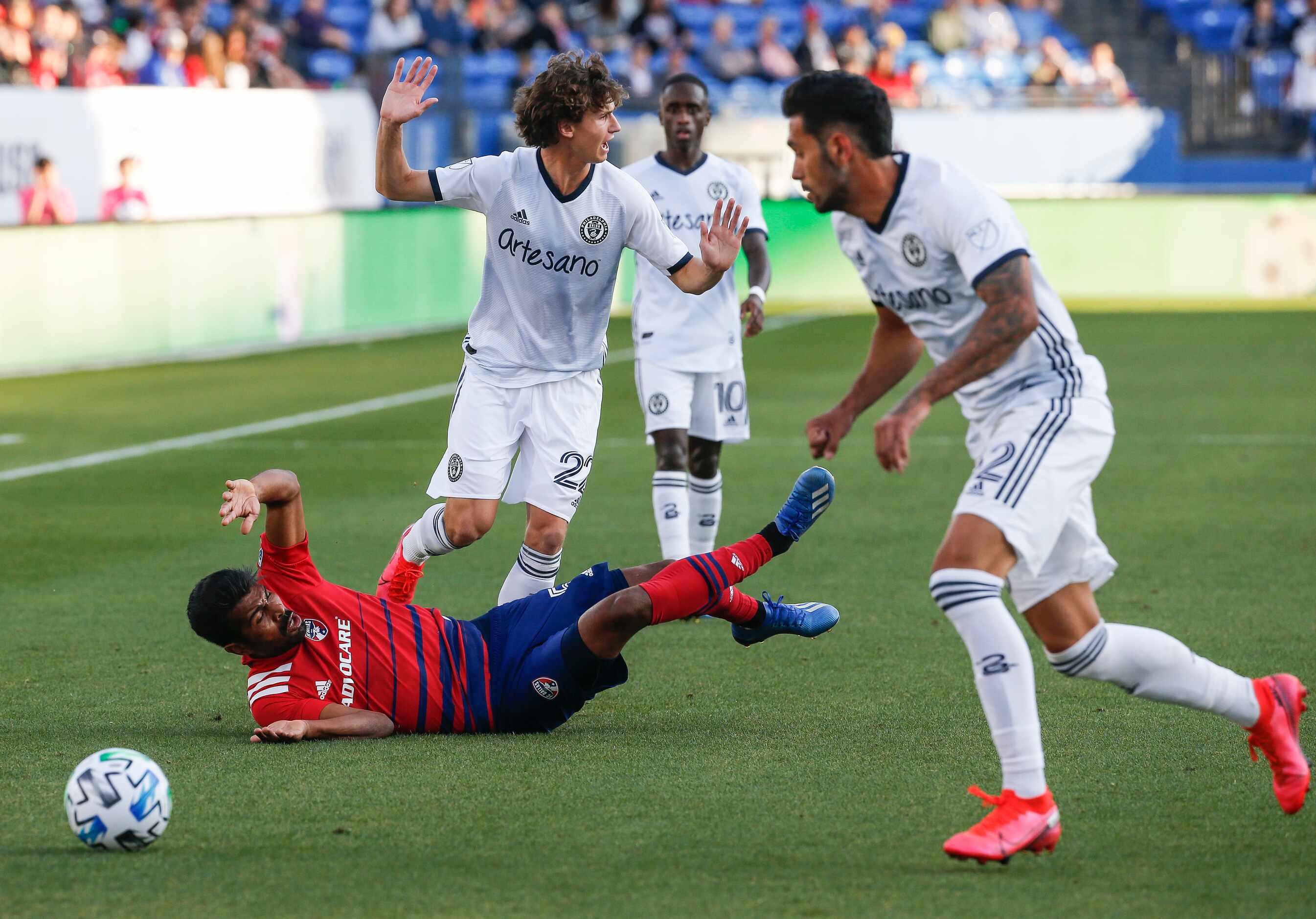 FC Dallas midfielder Thiago Santos (5) is upended while battling with Philadelphia Union...