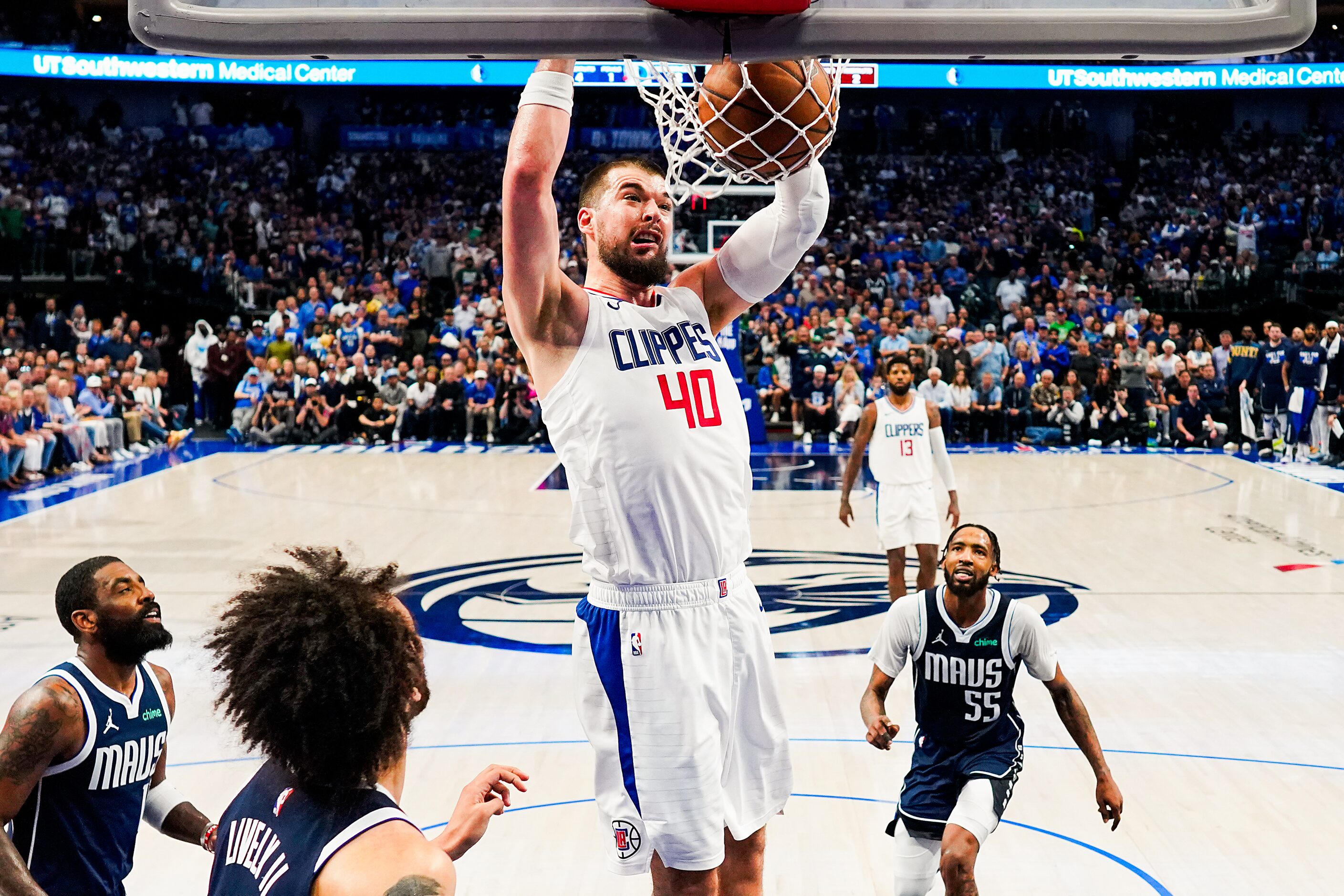 LA Clippers center Ivica Zubac (40) dunks the ball past Dallas Mavericks guard Kyrie Irving...