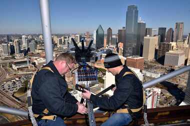 Pyrotechnicians Randy Linn (left) and Mike Cartolano of Melrose Pyrotechnics sit on beams...