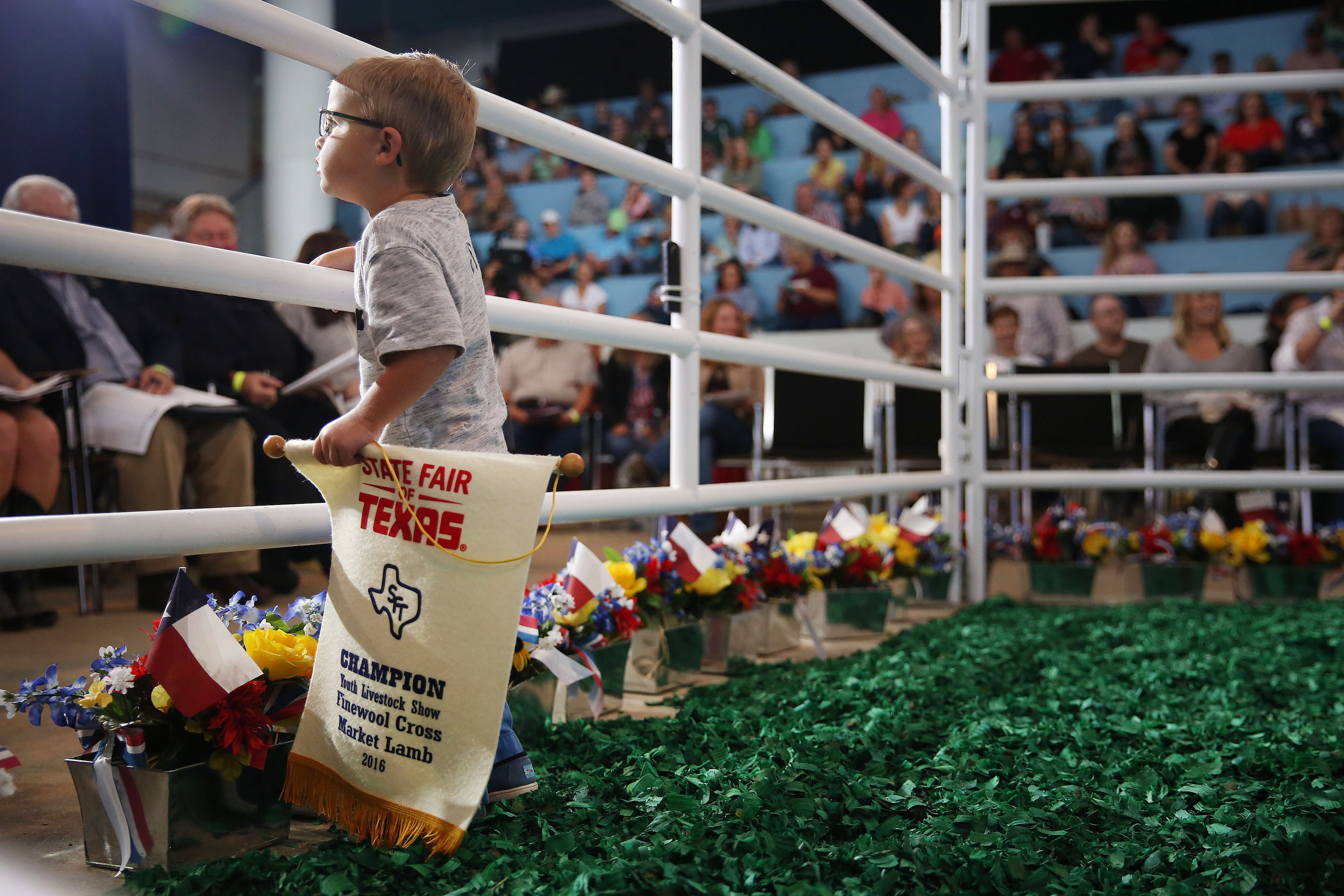 Nixon Rea, 2, looks out from the ring as his sister Ella Rea, 10, of San Angelo, Texas,...