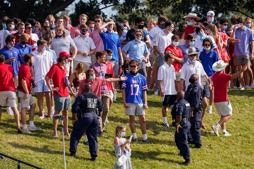  SMU students argue with law enforcement as they clear fans from the hill in the south end...