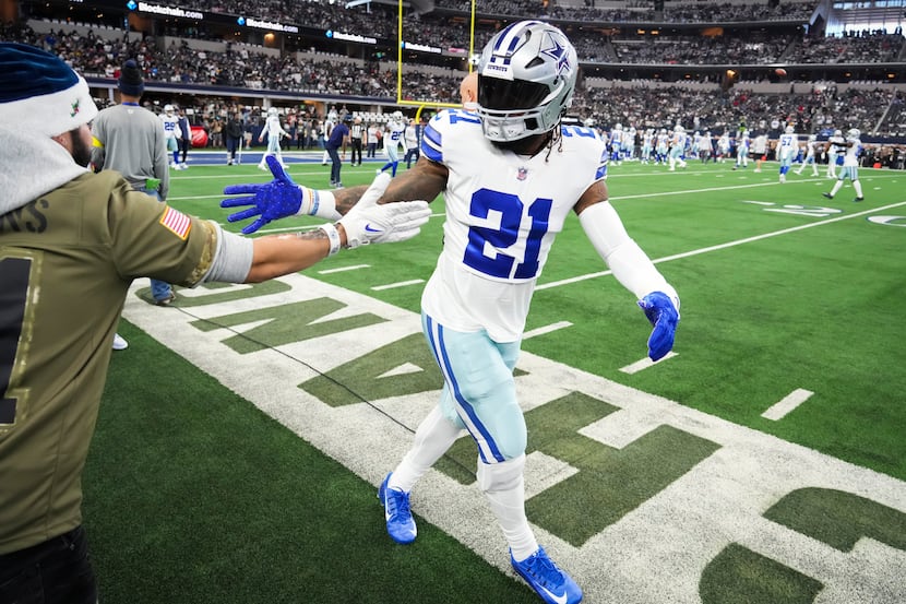 Dallas Cowboys running back Ezekiel Elliott (21) greets a fan before an NFL football game...
