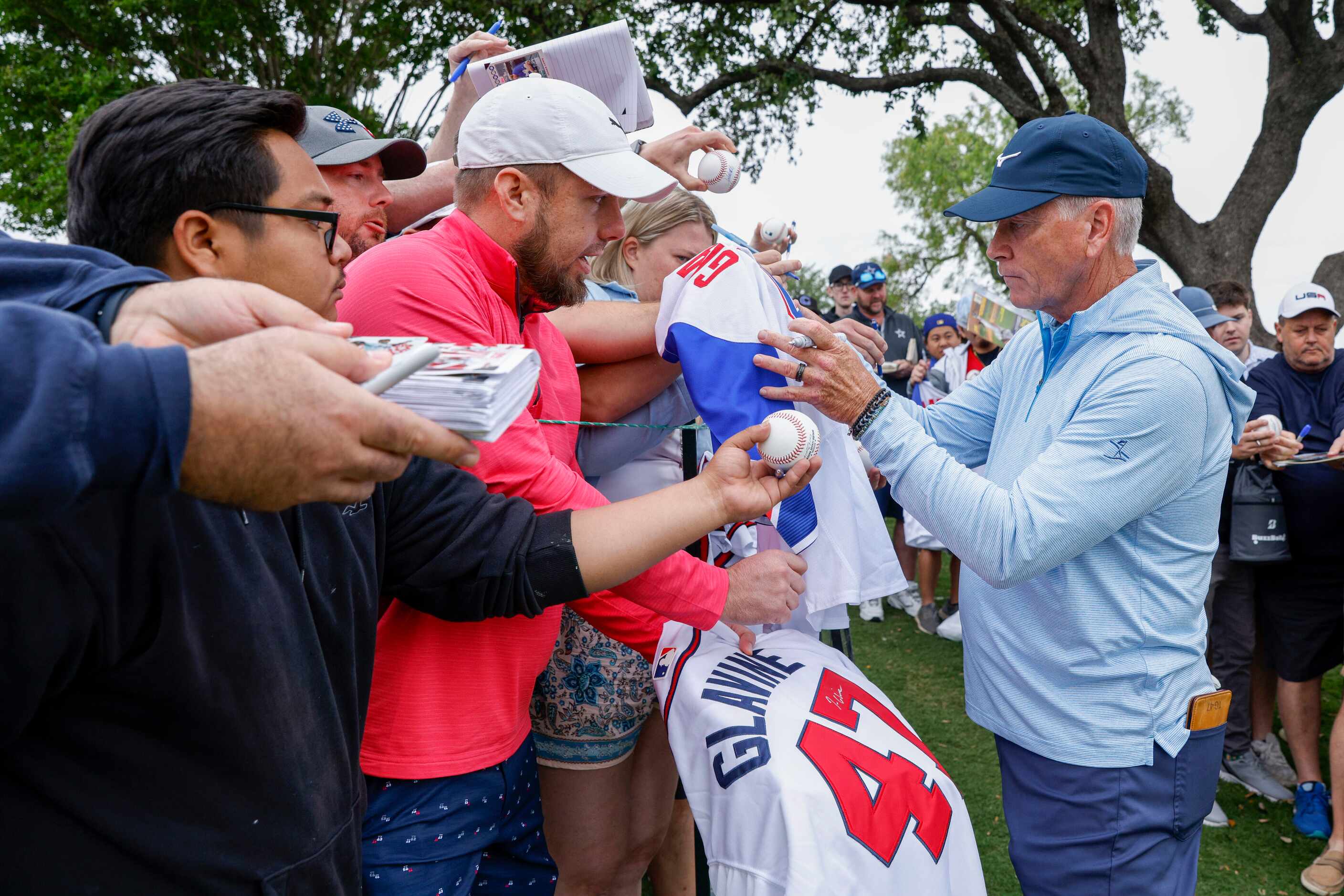 Former MLB pitcher Tom Glavine signs autographs for fans after completing the first round of...