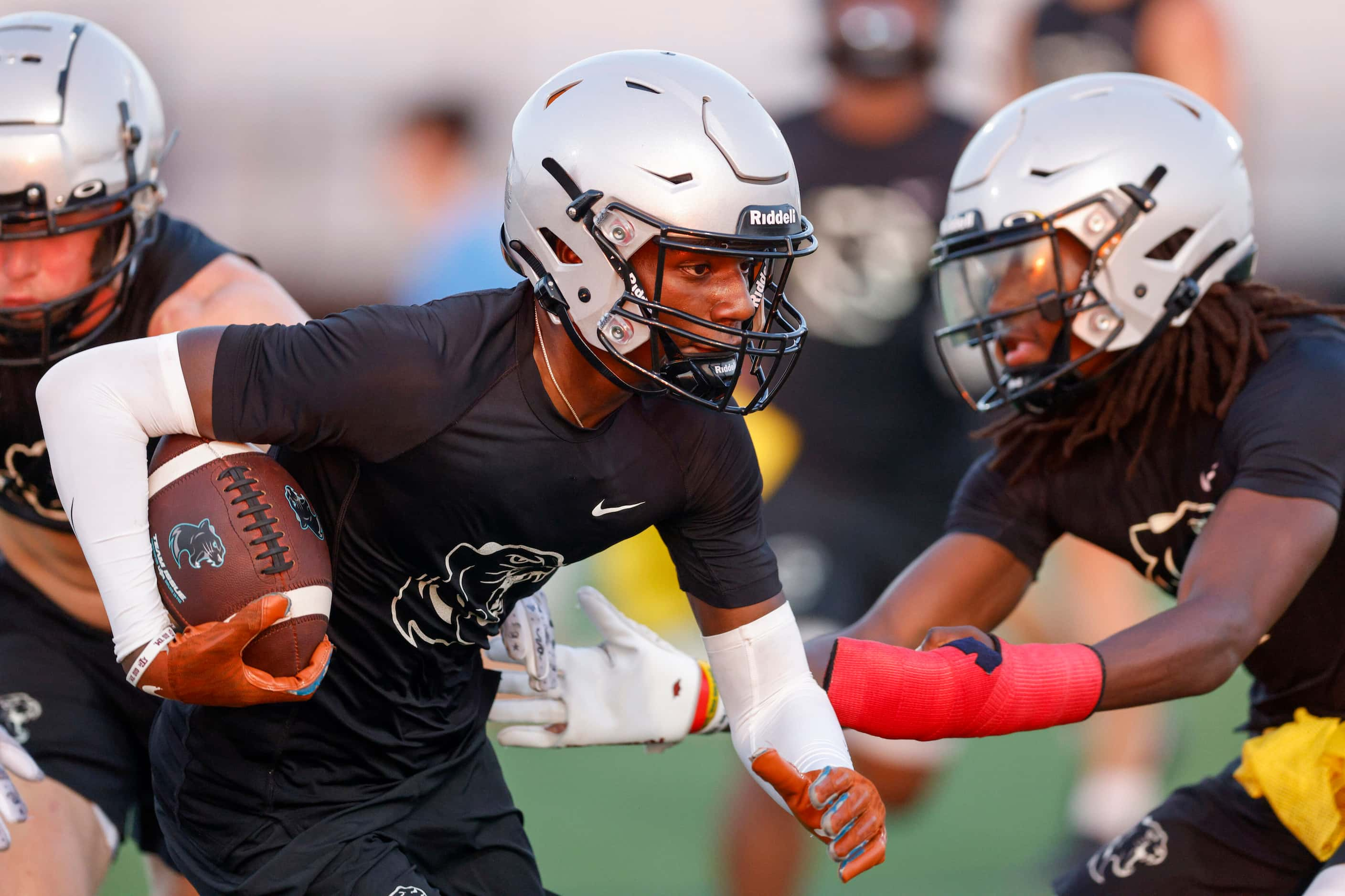 Wide receiver Jalen Lott runs through a pair of defenders during an early morning practice...