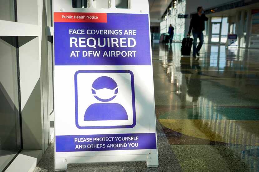 U cartel en el Aeropuerto DFW indica que debe utilizarse mascarilla dentro del lugar por la...