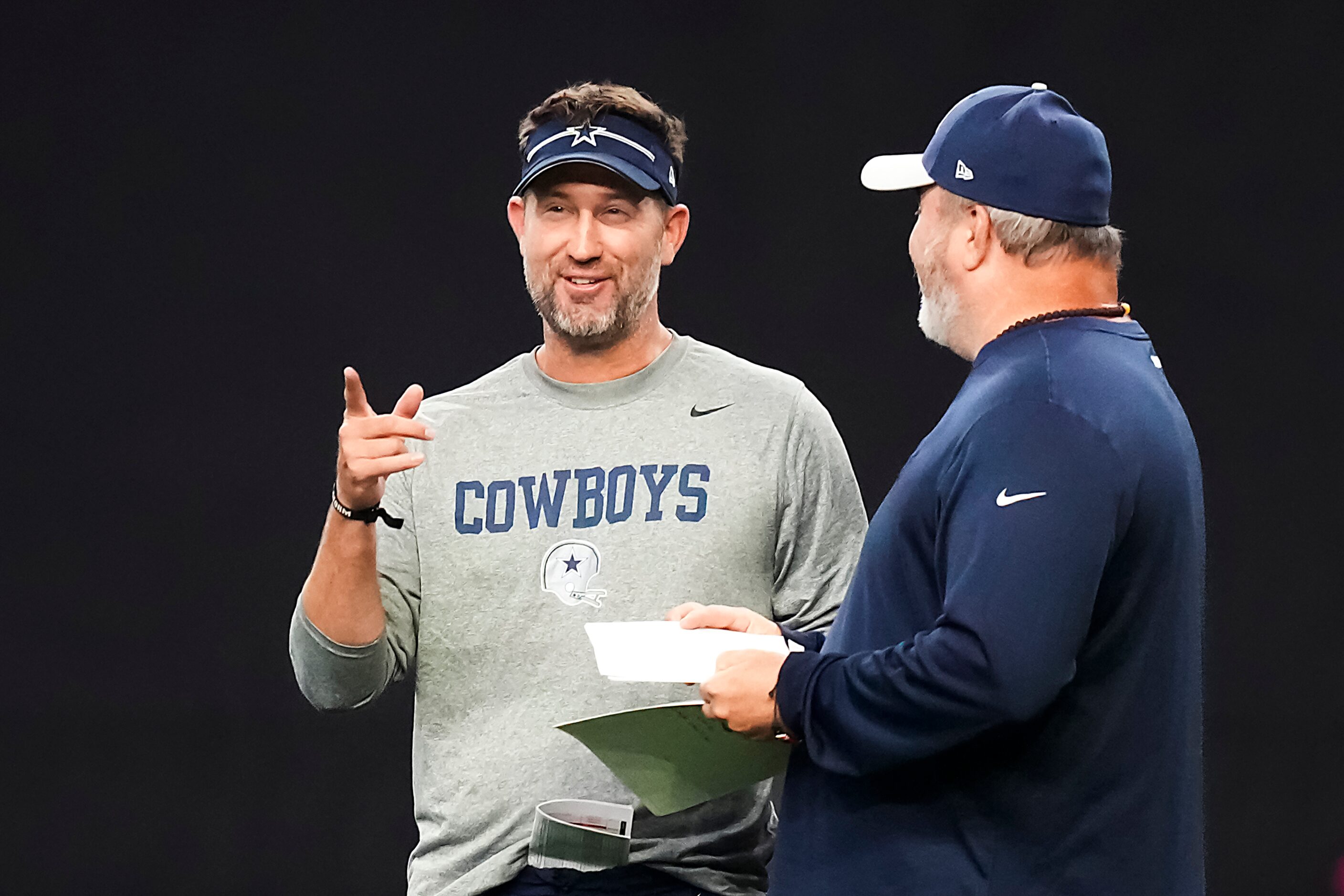 Dallas Cowboys offensive coordinator Brian Schottenheimer talks with head coach Mike...