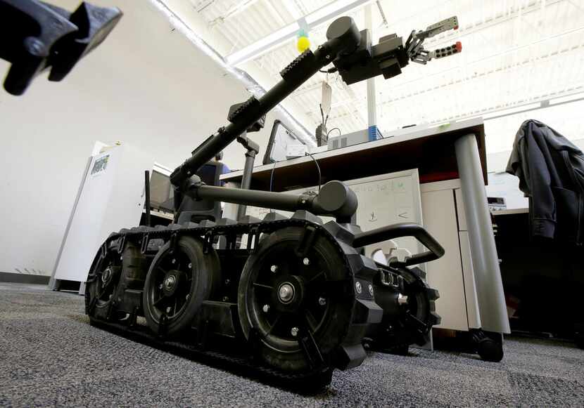 A Centaur robot rests on a carpeted floor between desks at Endeavor Robotics in Chelmsford,...