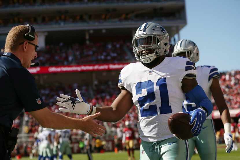 Dallas Cowboys running back Ezekiel Elliott (21) is congratulated by head coach Jason...