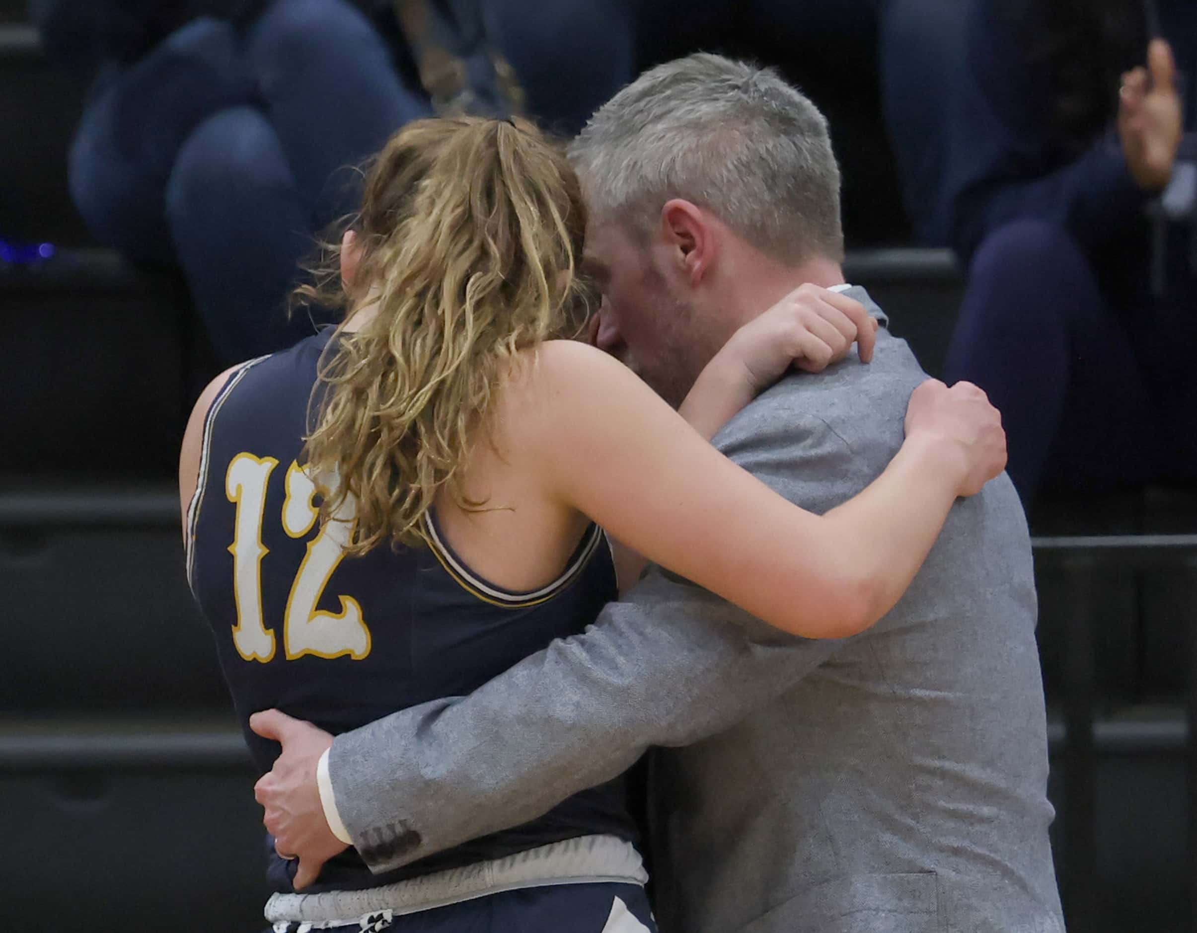 Highland Park head coach Todd Monsey consoles senior Ali Jackson (12) and another player...