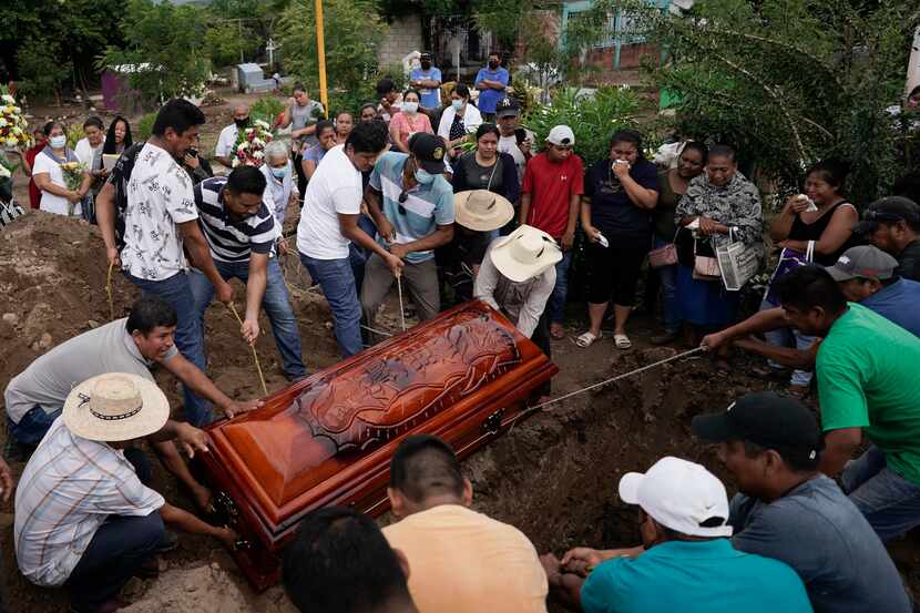 Residents bury Wilmer Rojas the day after he was killed in a mass shooting in San Miguel...