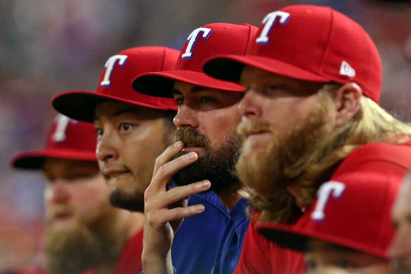 From left, Texas Rangers pitchers Yu Darvish, Cole Hamels and A.J. Griffin watch the game...