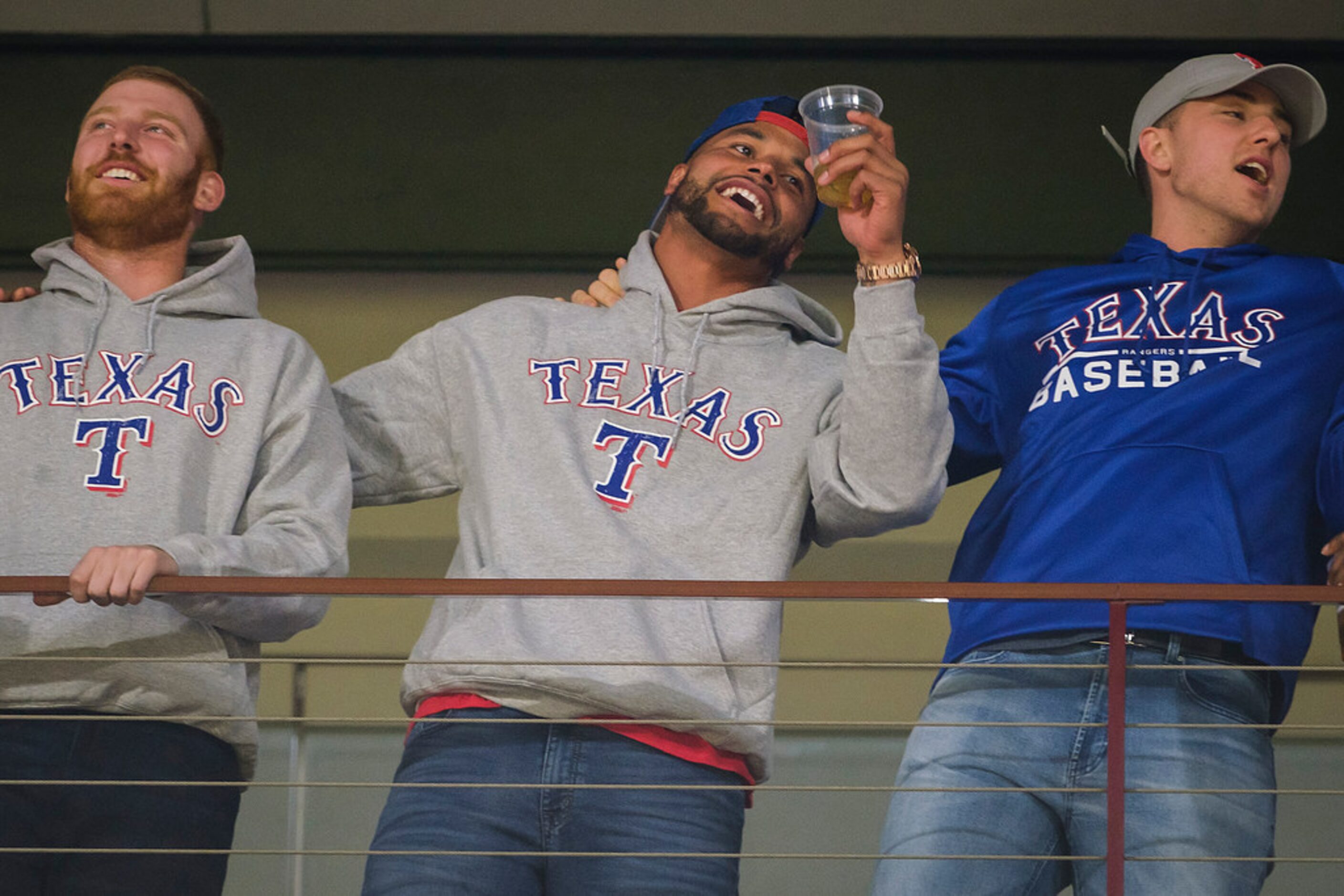 Dallas Cowboys quarterback Dak Prescott (center) cheers for the Texas Rangers during the...